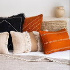 Assorted colorful pillows on a sofa against a neutral background