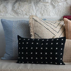 Colorful pillows on a sofa against a stone wall background