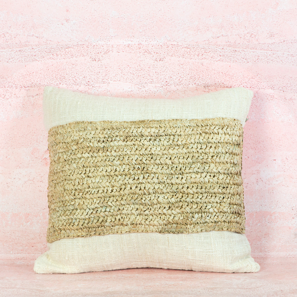 Decorative pillow with natural woven pattern on a pink background