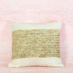 Decorative pillow with natural woven pattern on a pink background