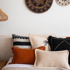 Decorative pillows on a sofa with woven wall art in the background