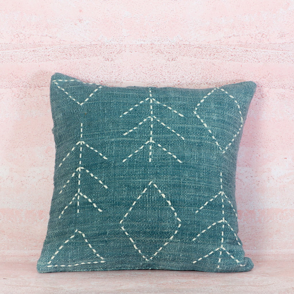 Light blue cushion with white stitching 