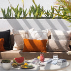 Outdoor seating area with colorful pillows and a small table with snacks and drinks