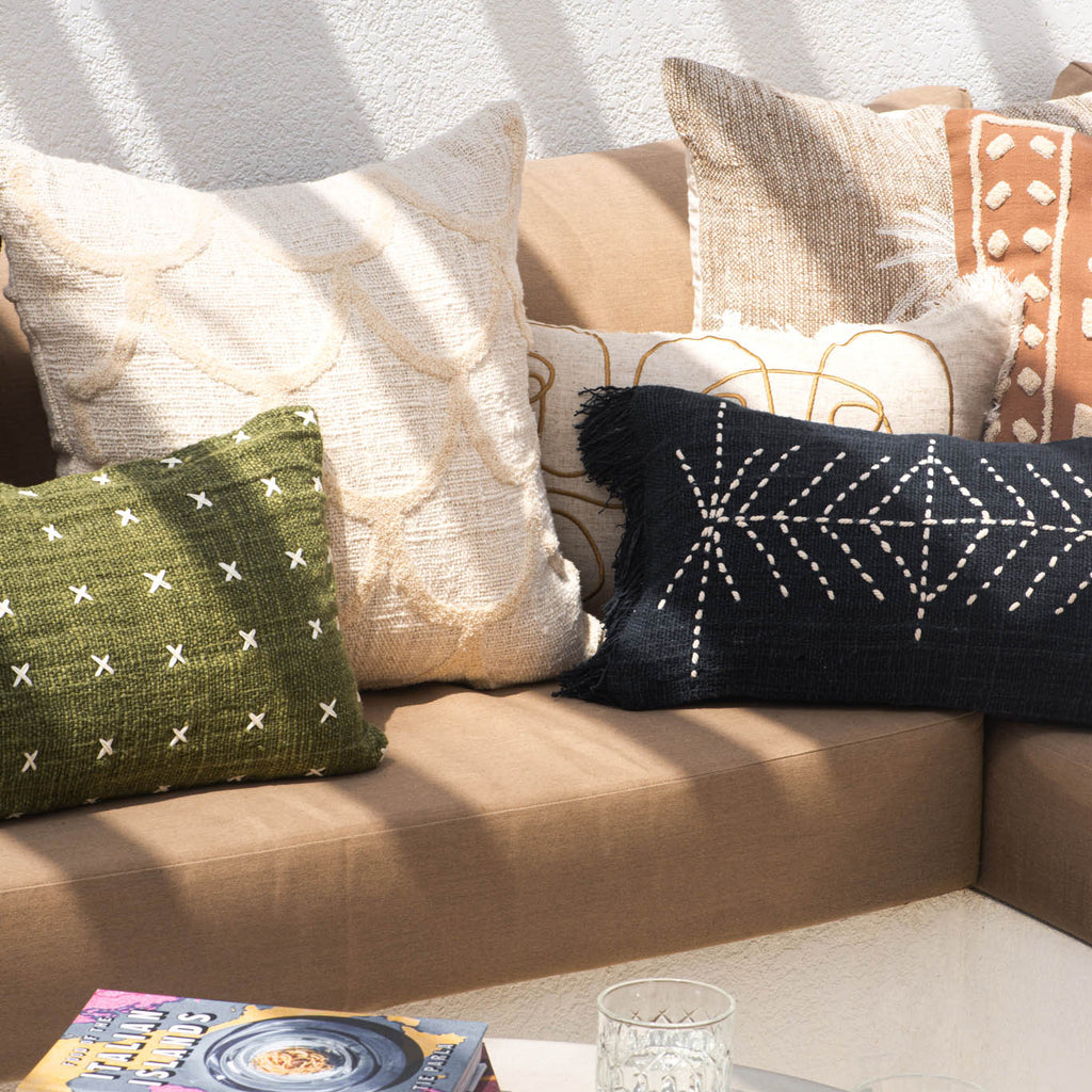 Decorative pillows on a beige sofa with a coffee table featuring lemons and books.