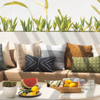 Outdoor seating area with a sofa, cushions, and a small table with fruit and drinks.