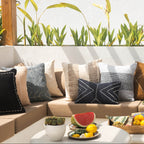 Outdoor seating area with a sofa, cushions, and a small table with fruit and drinks.
