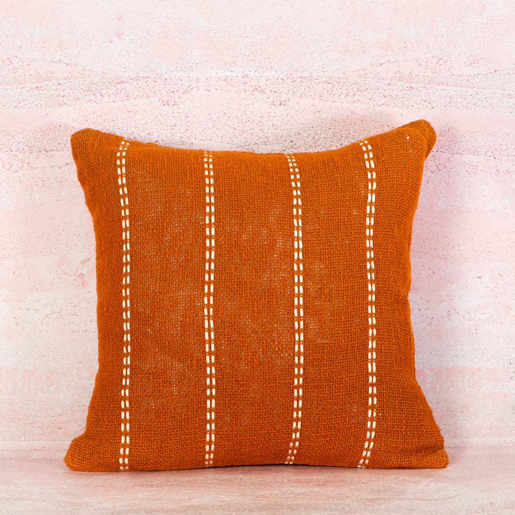 Terracotta pillow with white stitching 