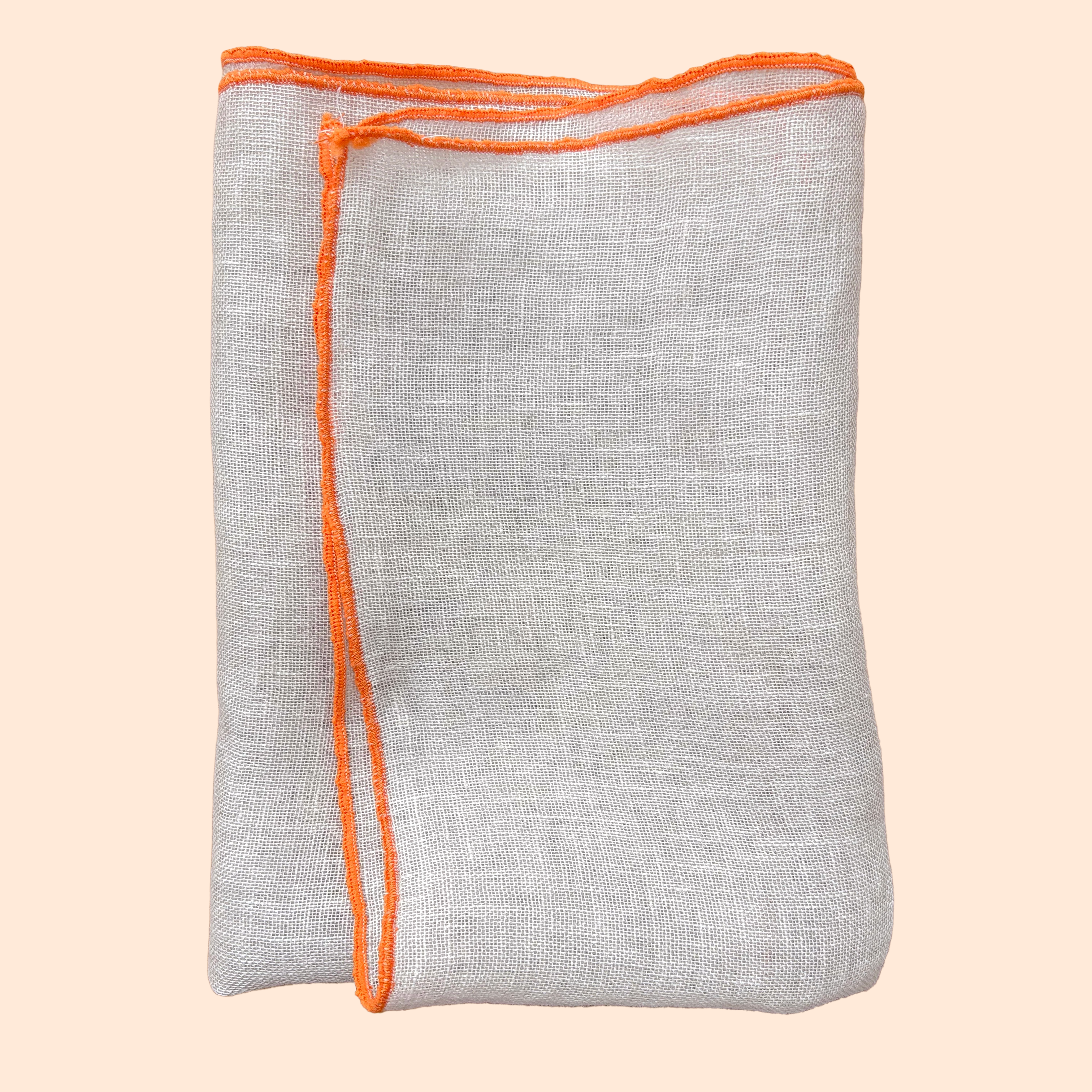 Isolated product image of natural linen napkin with orange hem on soft background